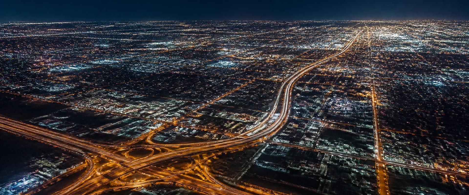 Aerial view of an illuminated city grid at night